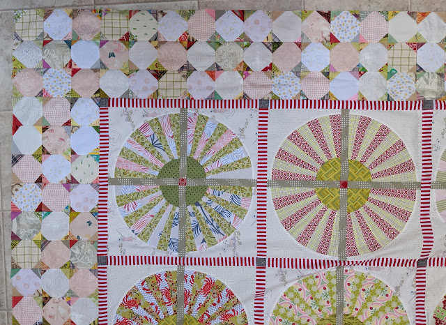 A portion of the Wheel quilt showing some of the wheels with a narrow red and white striped sashing and a border of three rows of low volume snowball blocks 