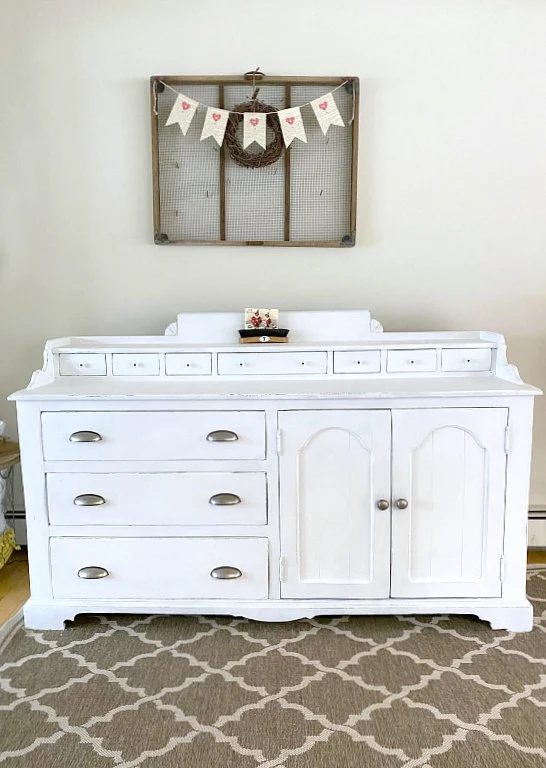 Farmhouse sideboard with sifting bin on wall above.