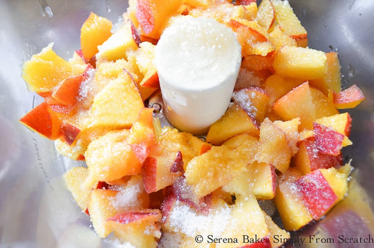 Diced Peaches and Sugar in a food processor.