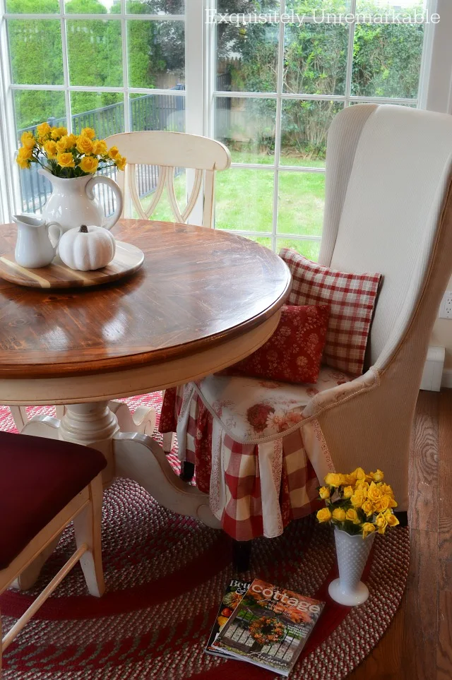 Country Style Kitchen table with skirted chair and braided rug