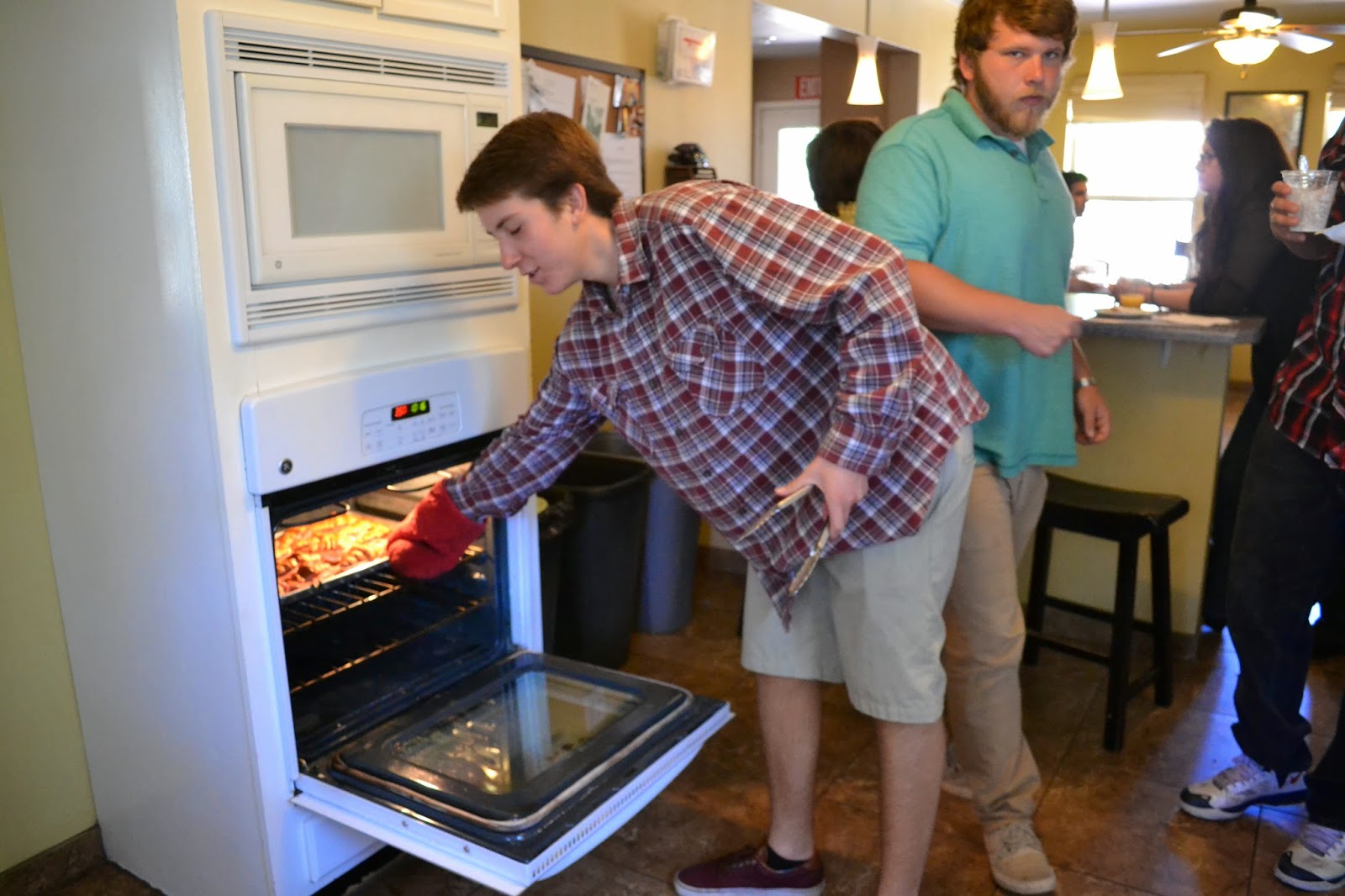 young man making bacon in the oven