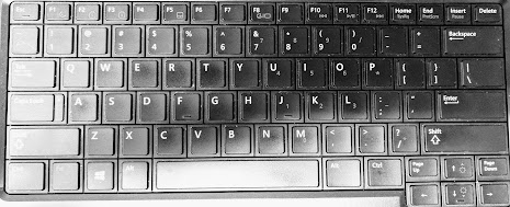 A photo of a computer keyboard in black and white.