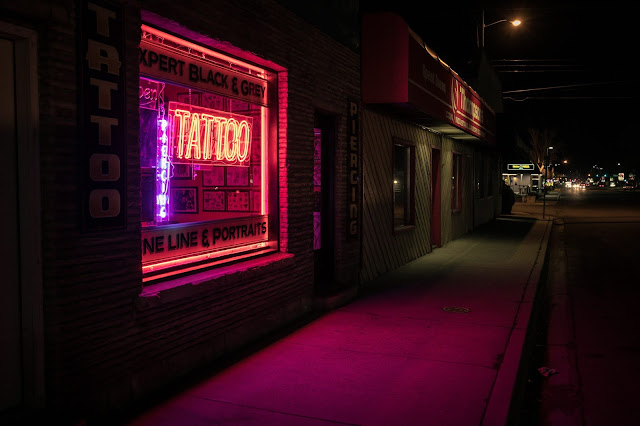 A tattoo LED sign at night.