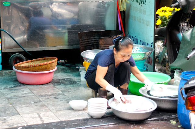 Lavando louça na rua no Vietnã