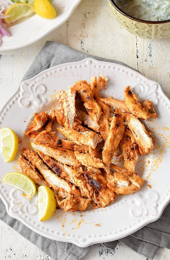 a white plate with grilled shredded chicken