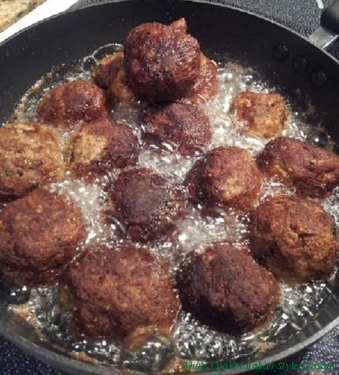 this is ground beef with herbs and spices added to make a round ball then fried in oil in a pan these are cooking in a heavy fry pan and the meatballs will be crispy on the outside and soft inside nicely browned using vegetable or canola oil