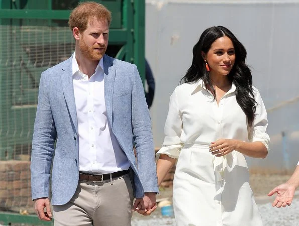 Meghan Markle wore a white belted shirt dress, and Madewell stone and tassel earrings, Stuart Weitzman suede pumps