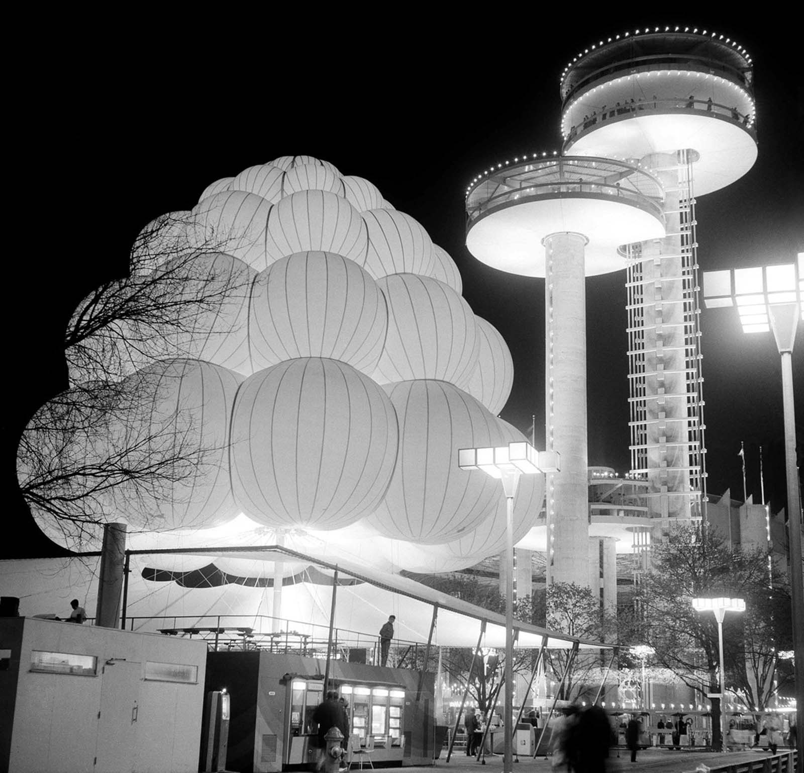 One of the Brass Rail lunch bars at the World's Fair gives the appearance of a mass of balloons tied together on August 11, 1964. The towers at right are observation platforms, part of the New York State pavilion.