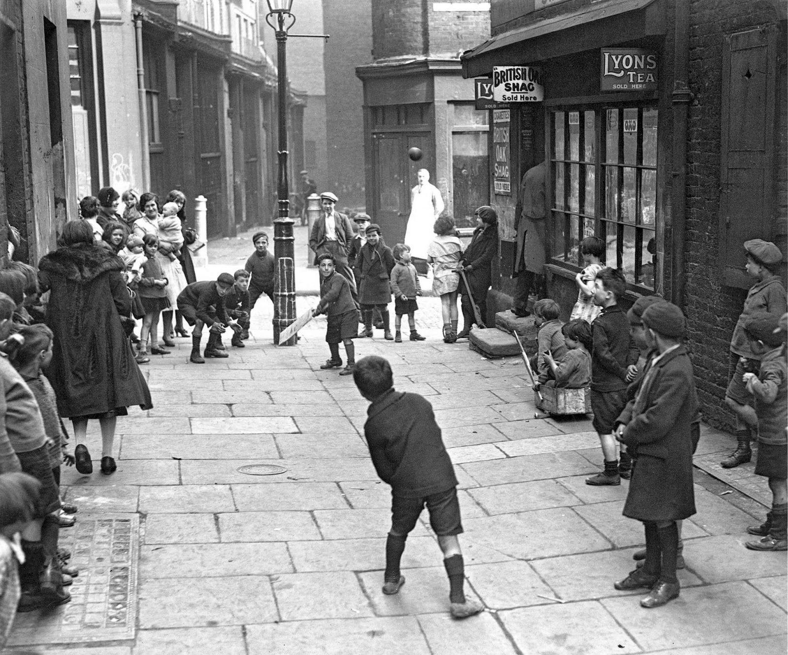 Children playing cricket in a London street (1930)