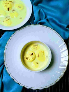 Serving rasmalai garnished with saffron and nuts for rasmalai recipe