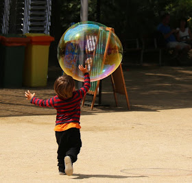 Kind spielt mit riesiger Seifenblase