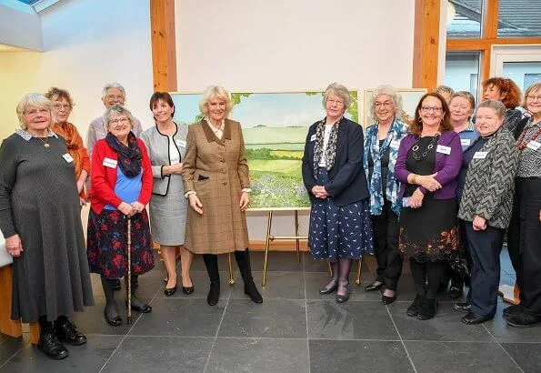 Camilla arrived at the hospice in a smart brown tweed two-piece, pairing the outfit with a simple cream blouse with over-the-knee boots