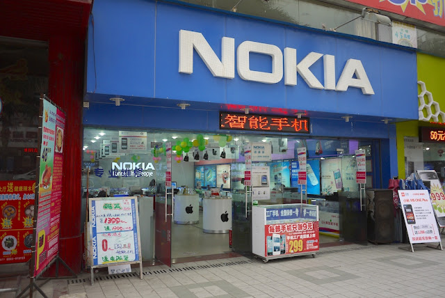 Store with large Nokia sign displaying Apple products