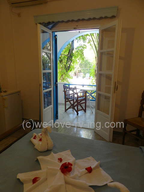 The decorated bed and the door leading to the patio looking at the pool