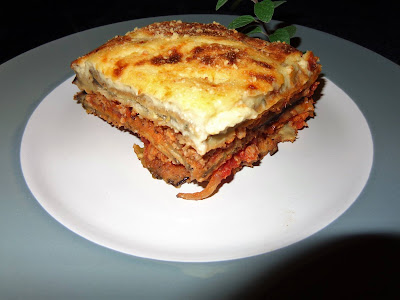 In the classic moussaka, the eggplant is sliced and fried in olive oil. It absorbs a lot of oil. I prefer to breaded and finish baking it, that way the moussaka is more firm and the layers do not slice off when serving hot. MOUSSAKA (GREEK) PORTIONS: 8 INGREDIENTS TO BREAD EGGPLANT 3 medium size eggplants, thinly sliced Flour 4 eggs bitten with a bit of milk  Italian seasoned breadcrumbs. INGREDIENTS FOR MEAT SAUCE 1lb. ground lamb or beef 2 tbsp. vegetable oil 1 diced onion 3 minced garlic cloves 2 tsp. chopped fresh oregano ¼ tsp. cinnamon powder 1/8 tsp. ground nutmeg ½ tbsp. paprika ¼ tsp. red pepper flakes 1 (28 oz.) can diced tomatoes ¾ cup tomato sauce INGREDIENTS FOR BECHAMEL SAUCE 1 tbsp. vegetable oil 6 tbsp. butter ¾ cup all-purpose flour 3½ cups milk ½ cup crumbled goat cheese or feta cheese 3 beaten eggs SPRINKLE THE TOP 2 tbsp. parmesan cheese METHOD Chop and Measure all ingredients provided for the recipe. EEGGPLANT Dip the eggplant in flour, eggs and bread crumbs. Spray with oil a baking sheet pan, place the eggplant over it in a single layer and bake it at 350° F. until the crust is slightly brown. MEAT SAUCE Heat a frying pan with the vegetable oil and slightly cook onions and garlic. Add the meat you desire to use and brown it together with the onions and garlic. Incorporate cinnamon powder, nutmeg, paprika, red pepper flakes, mix well and cook for a couple of minutes. Add to the meat the juices of the can tomatoes. Chop the tomatoes a little bit and add to the sauce. Finish adding the tomato sauce. BECHAMEL SAUCE In a pot heat the oil and melt the butter. Add flour and cook it at moderate heat for a few minutes, be careful not to burn flour.  Pour the milk a little bit at the time and mix well. Add crumbled cheese and let cook the sauce for about 10 minutes. Stir very often. Do not let flour to stick or burn at the bottom of the pot. In a large bowl beat well the eggs and pour the béchamel slowly into the eggs and stirring fast at the same time, so the eggs has no time to coagulate. ASAMBLING THE DISH In a baking dish place one layer of the eggplant. On top spread half of the tomato sauce. Lay more eggplant on top, and spread the rest of the sauce. Place the last layer of eggplant and cover with the béchamel sauce. Sprinkle the top with parmesan cheese. Bake the moussaka at 325° F for about 1 hour. Turn the oven on to broiler and brown it for about 10 minutes. Be careful not to burn the top of the moussaka. EGGPLANT Dip the eggplant in flour, eggs and bread crumbs. Spray with oil a baking sheet pan, place the eggplant over it in a single layer and bake it at 425° F. until the crust is slightly brown. MEAT SAUCE Heat a frying pan with the vegetable oil and slightly cook onions and garlic. Add the meat you desire to use and brown it together with the onions and garlic. Incorporate cinnamon powder, nutmeg, paprika, red pepper flakes, mix well and cook for a couple of minutes. Add to the meat the juices of the can tomatoes. Chop the tomatoes a little bit and add to the sauce. Finish adding the tomato sauce. BECHAMEL SAUCE In a pot heat the oil and melt the butter. Add flour and cook it at moderate heat for a few minutes, be careful not to burn flour.  Pour the milk a little bit at the time and mix well. Add crumbled cheese and let cook the sauce for about 10 minutes. Stir very often. Do not let flour to stick or burn at the bottom of the pot. In a large bowl beat well the eggs and pour the béchamel slowly into the eggs and stirring fast at the same time, so the eggs has no time to coagulate. ASAMBLING THE DISH In a baking dish place one layer of the eggplant.  On top spread half of the meat sauce.  Lay more eggplant on top and spread the rest of the sauce. Place the last layer of eggplant on top  Cover with the béchamel sauce. Sprinkle the top with parmesan cheese. Bake the moussaka at 325° F for about 1 hour. Turn the oven on to broiler and brown it for about 10 minutes. Be careful not to burn the top of the moussaka.