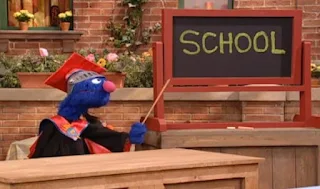 Super Grover is dressed like a professor. Sesame Street Episode 4071, Professor Super Grover's School for Superheroes