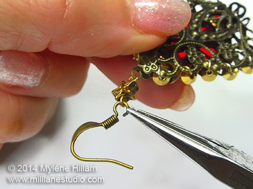 The loop of the earring wire has been opened and the star bead has been hooked on.