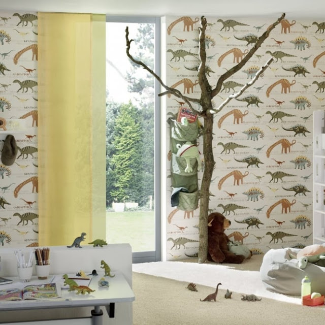 Dinosaur wallpaper in a child's room with toys, a desk and a bean bag around the room