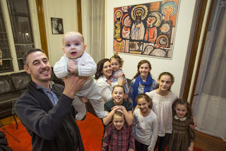 Jose and Maribel Martin and their eight children in the rectory of St. Charles Borromeo Catholic Church in Philadelphia. The Martins, missionary followers of the Neocatechumenal Way, a faith formation program, have been assigned to the South Philadelphia parish to help revitalize parish life in the neighborhood. Jose holds up the couple’s youngest son, Santiago, 4 months.