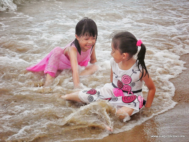 Crianças brincando na praia ao entardecer