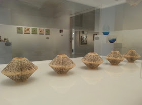 Small folded book art on display in a gallery.