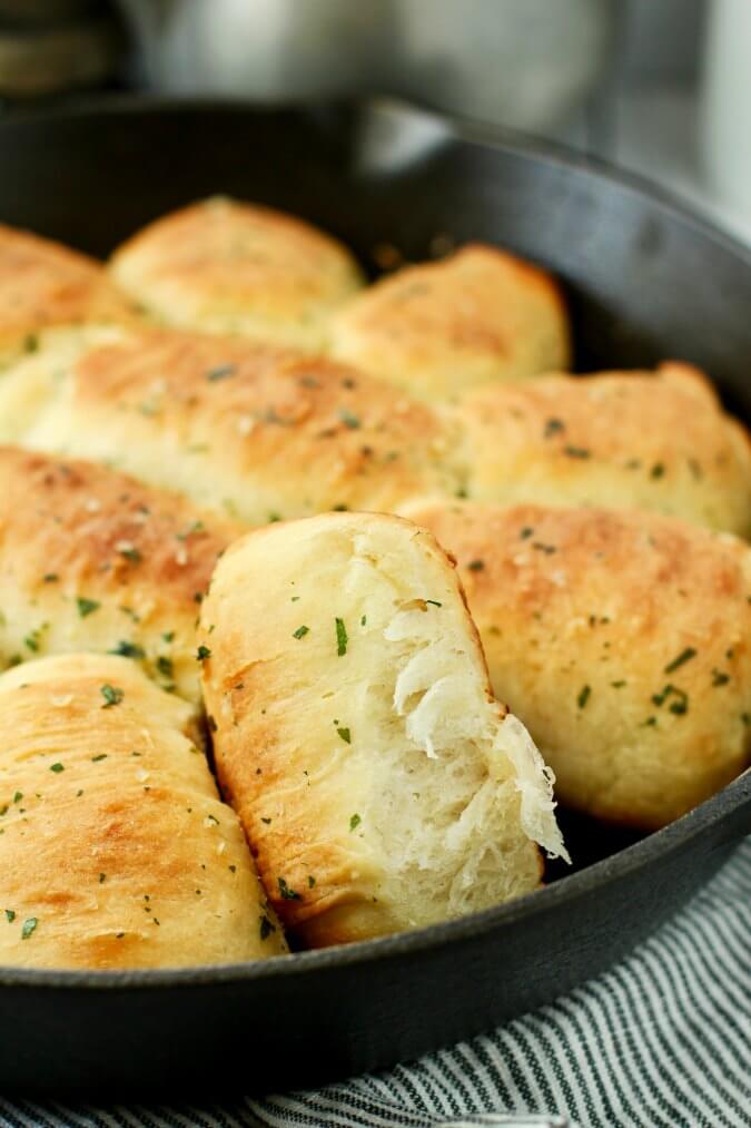Pull apart rolls in a cast iron skillet brushed with garlic herb butter
