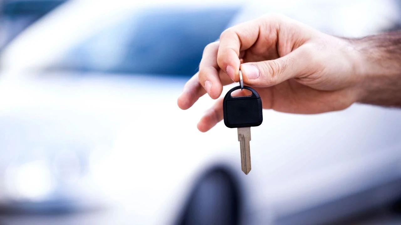 Owner of the car gives the car key to new owner.