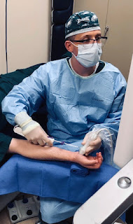 Matthew Miller holds a patient's arm