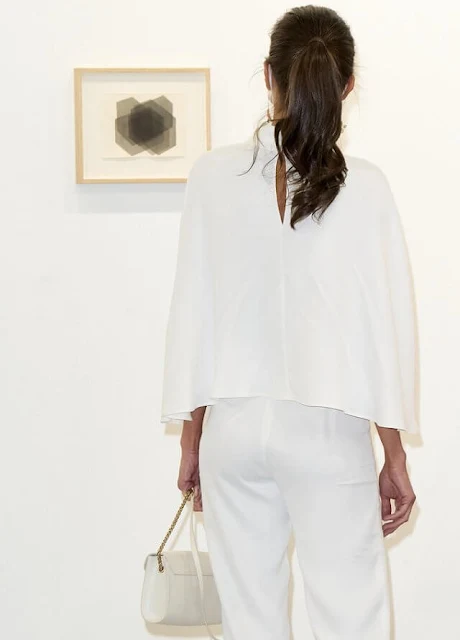 Queen Letizia wore a new short cape by On Atlas, and falling jasmine earrings by Carolina Herrera. Furla white leather shoulder bag