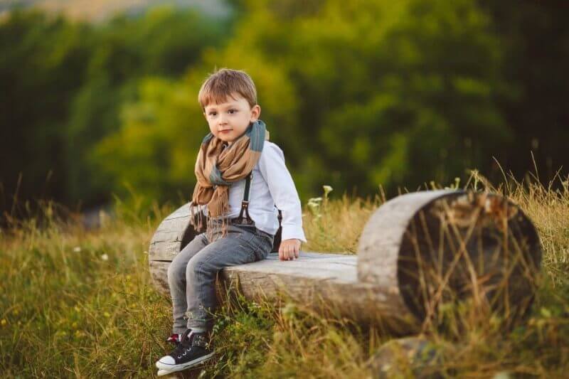 صورة طفل صغير يجلس في وسط البستان