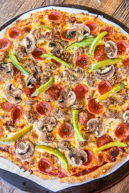Keto Pizza Crust - a delicious low-carb friendly pizza crust! SO easy to make and tastes great! Almond flour, parmesan cheese, oregano, salt, coconut oil, and an egg. Only takes a minute to make. Top with a sugar-free pizza sauce, mozzarella, and your favorite pizza toppings. Tastes like you are cheating, but you aren't! #pizza #keto #lowcarb #glutenfree pizza on pizza stone