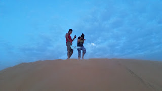 Two tourists on top of a sand dune in Muine, Vietnam