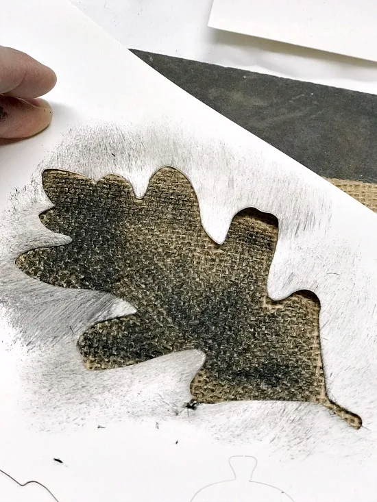 Stenciling an oak leaf with black paint