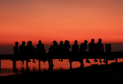 Image of people sitting on dock titled "Friends" by Christos Loufopoulos (ophilos on flickr) Taken on August 18th, 2011 (CC-by-2.0)