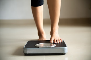 Woman Stepping on Weight Scale