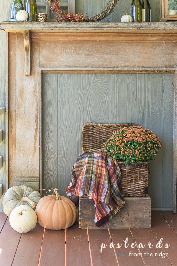 rustic fall mantel with fall decor and basket with plaid blanket scarf and mums