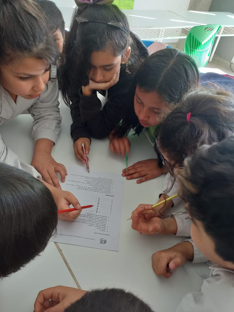 trabajo en grupo varios niños produciendo  un texto