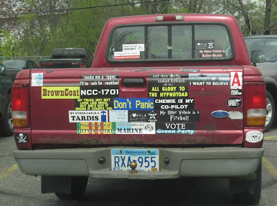 Red Ford pickup with two dozen bumper stickers