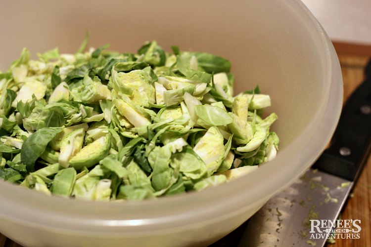Sliced Brussels Sprouts in a white bowl ready for Sauteed Brussels Sprouts with Bacon by Renee's Kitchen Adventures