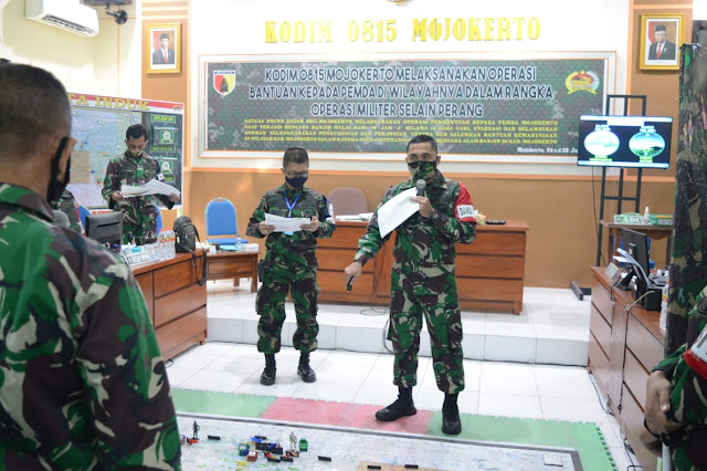 Mojokerto, - Kodim 0815/Mojokerto Melaksanakan Operasi Bantuan Kepada Pemerintah Daerah Di Wilayah Kabupaten Mojokerto Dalam Rangka Operasi Militer Selain Perang (OMSP) khususnya dalam Penanggulangan Bencana Alam & Bantuan Kemanusiaan, merupakan tema yang diusung dalam Latihan Posko – 1 Kodim 0815/Mojokerto.   Dandim 0815/Mojokerto, Letkol Inf Dwi Mawan Sutanto, SH., selaku Dansatgas Pasukan Reaksi Cepat Penanggulangan Bencana (PRCPB) Kabupaten Mojokerto dalam Lat Posko – 1 Kodim 0815/Mojokerto, saat dikonfirmasi, Jum’at (26/06/2020) mengungkapkan, Latihan Posko ini bertujuan untuk memelihara dan meningkatkan kemampuan prosedur hubungan antara Komandan dan Staf dalam merencanakan, mempersiapkan dan melaksanakan operasi serta komando dan pengendalian dalam penanggulangan bencana alam di wilayah.  “Latihan Posko ini, sebagai wahana untuk meningkatkan kemampuan Prajurit Kodim 0815/Mojokerto, dalam merencanakan, mempersiapkan dan melaksanakan operasi serta komando dan pengendalian dalam penanggulangan bencana alam di wilayah,” tandasnya.  Masih lanjut Dandim, Latihan Posko – 1 ini, disesuaikan dengan kondisi geografi wilayah Kabupaten Mojokerto, khususnya bagian selatan, yang merupakan daerah pegunungan yang berpotensi terjadinya bencana alam, seperti banjir, banjir bandang dan tanah longsor.    “Dalam latihan ini, disimulasikan terjadi bencana alam di kawasan rawan bencana (KRB) meliputi wilayah Kecamatan Pacet, Trawas dan Gondang. Kemudian PRCPB melakukan operasi penanggulangan bencana alam di ketiga wilayah tersebut yang terkonsentrasi di wilayah Kecamatan Pacet,” terangnya.  “Kondisi ini yang disimulasikan, kita gelar Operasi Penanggulangan Bencana Alam dalam rangka membantu Pemda, dengan melibatkan sejumlah satuan dan instansi terkait,” tambah Alumni Akmil Angkatan 2000 Kecabangan Infantri.  Sekedar informasi, Latihan Posko – 1 Kodim 0815/Mojokerto yang diselenggarakan Korem 082/CPYJ berlangsung selama tiga hari, Rabu hingga Jum’at (24-26/06-2020), dibuka Ws Danrem 082/CPYJ Letkol Arm Beni Sutrisno, S.Sos, di Makorem 082/CPYJ Jalan Veteran Nomor 3 Kota Mojokerto. (Jayak)