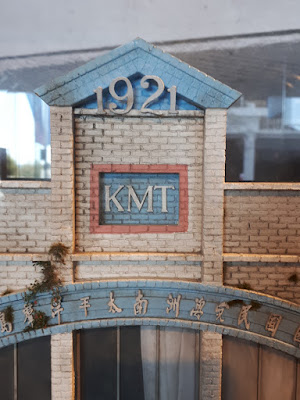 Detail of the top of a 1/24 scale model facade of an old three-storey commercial building with the date 1921 on the top.