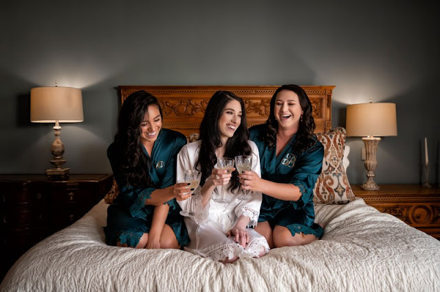 bride and bridesmaids in robes with champagne
