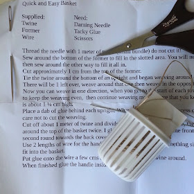 Printed instructions for a one-twelfth scale 'Quick and Easy Basket', with the kit pieces, a pair of scissors and a darning needle laid out on top.