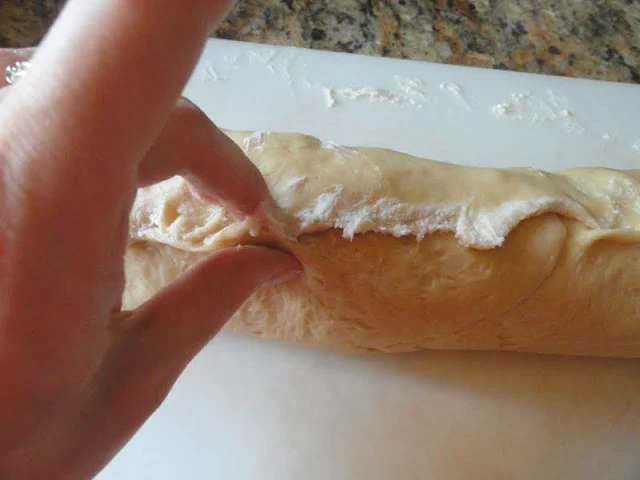 Cinnamon Roll dough log seam being pinched shut.