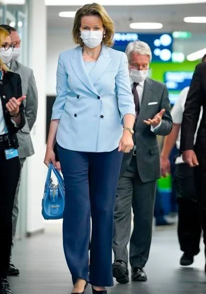 Queen Mathilde wore a blue double-breasted blazer by Emporio Armani. Queen carries Armani bag. Meghan Markle