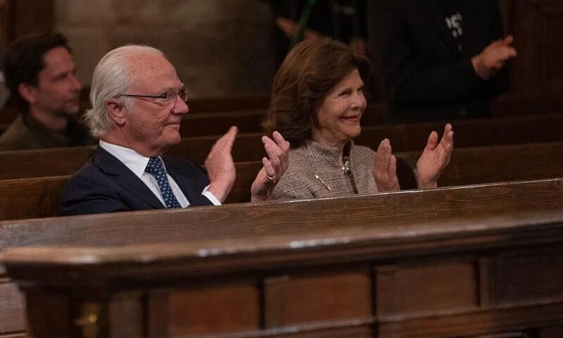 Queen Silvia wore a brown coat and dress from Newhouse Halifax at the Stockholm Early Music Festival 2021