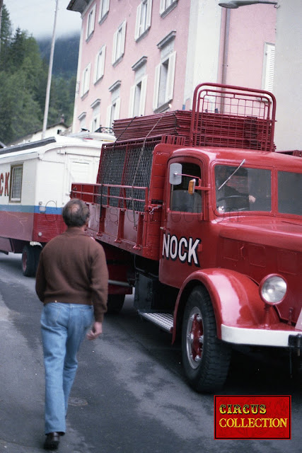 Camion. et roulotte  du cirque Nock traversant un village grisonais 