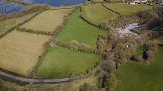 Drone photo of countryside from the air, middle fields (which are our land) are darker green.