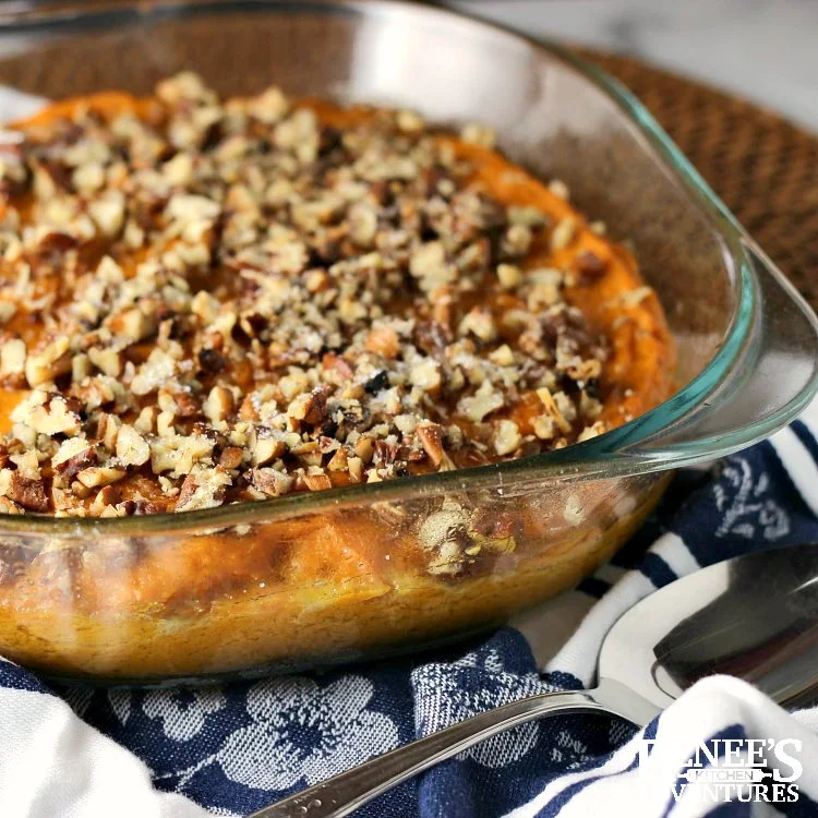 Sweet Potato Souffle Casserole by Renee's Kitchen Adventures in pan with spoon to the front on a white and blue napkin