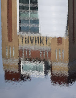 A reflection in the river Tyne of the top of half of The Baltic